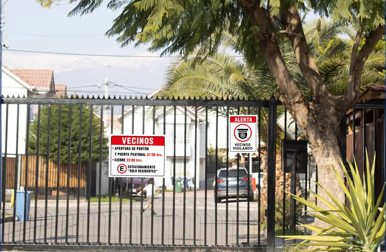 Reja de pasaje con letrero para vecinos sobre la apertura del portón